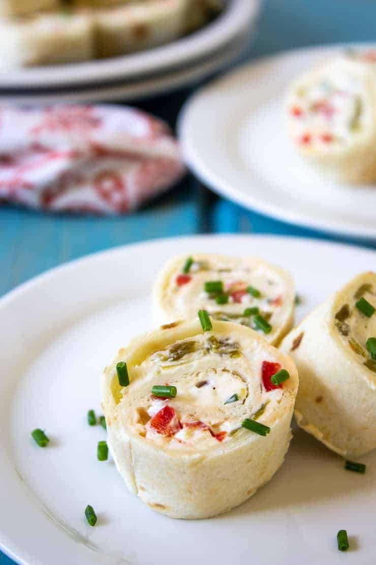 Mexican Tortilla Pinwheels on a plate sprinkled with chopped chives.