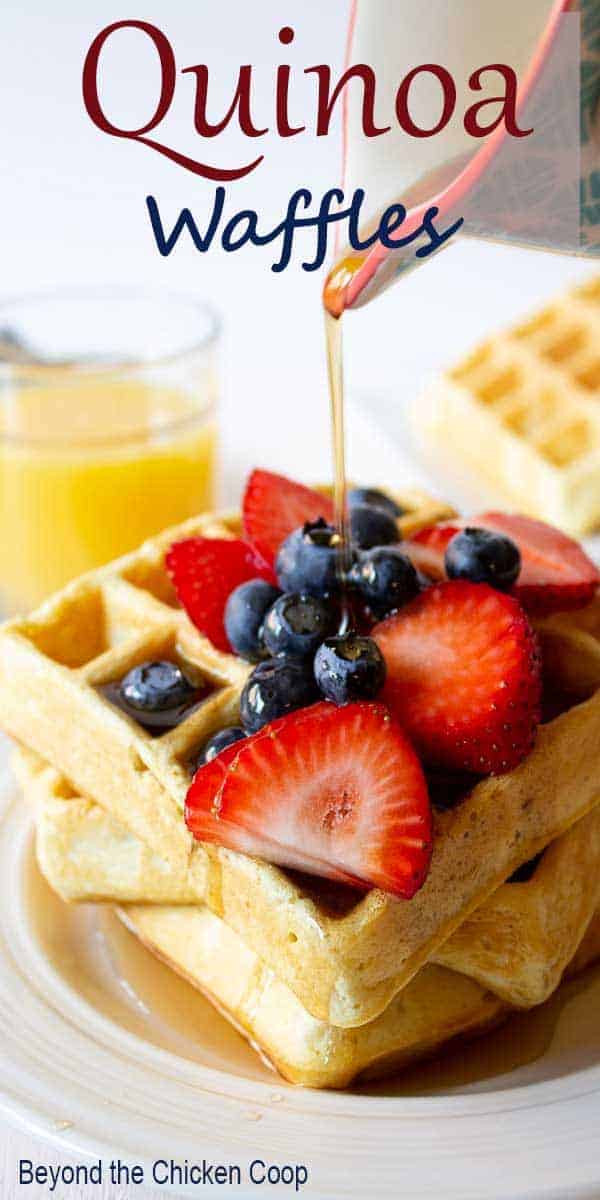 Syrup pouring onto waffles with fresh fruit.