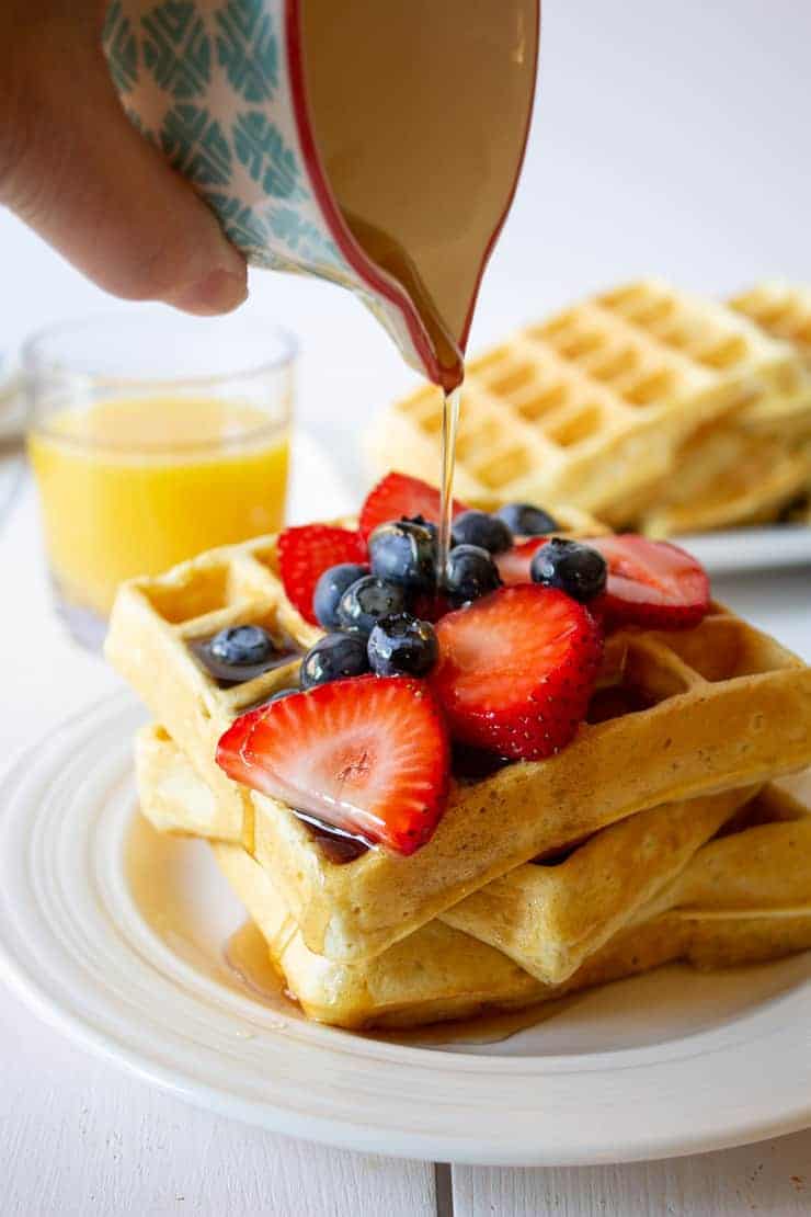 Pouring syrup onto waffles.