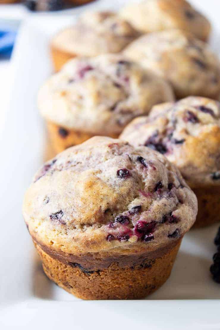 Freshly baked Homemade Blackberry Muffins on a white platter.