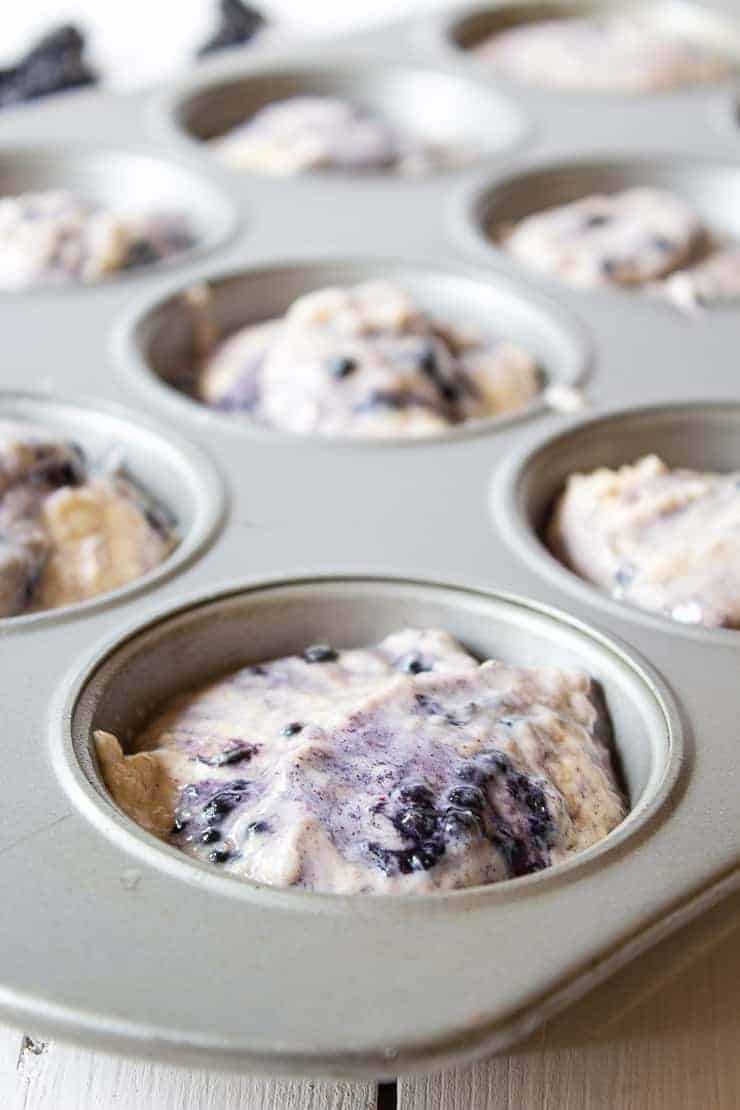 Blackberry muffin batter in muffin tins.