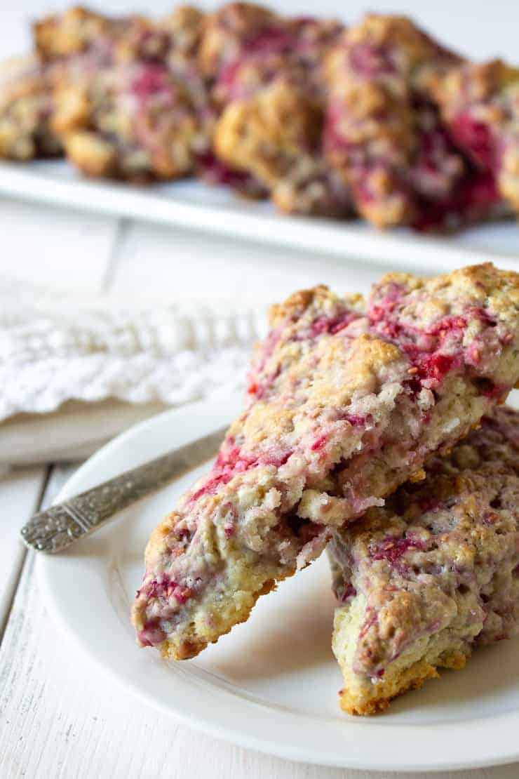 Raspberry scones stacked on a small white plate.