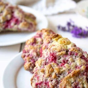 Two raspberry scones on a small white plate.