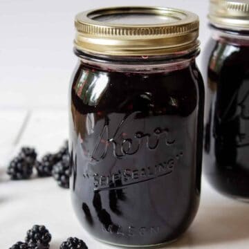 A glass canning jar filled with blackberry jam.