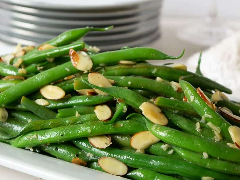 Cooked green beans topped with sliced almonds.
