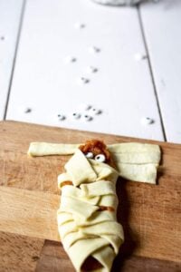 Adding candy googly eyes to Mummy Pumpkin Hand Pies