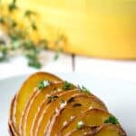 A sliced potato topped with fresh thyme.