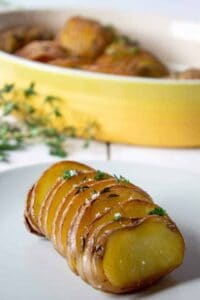 Roasted Hasselback potatoes with a sprinkle of coarse salt and fresh herbs.