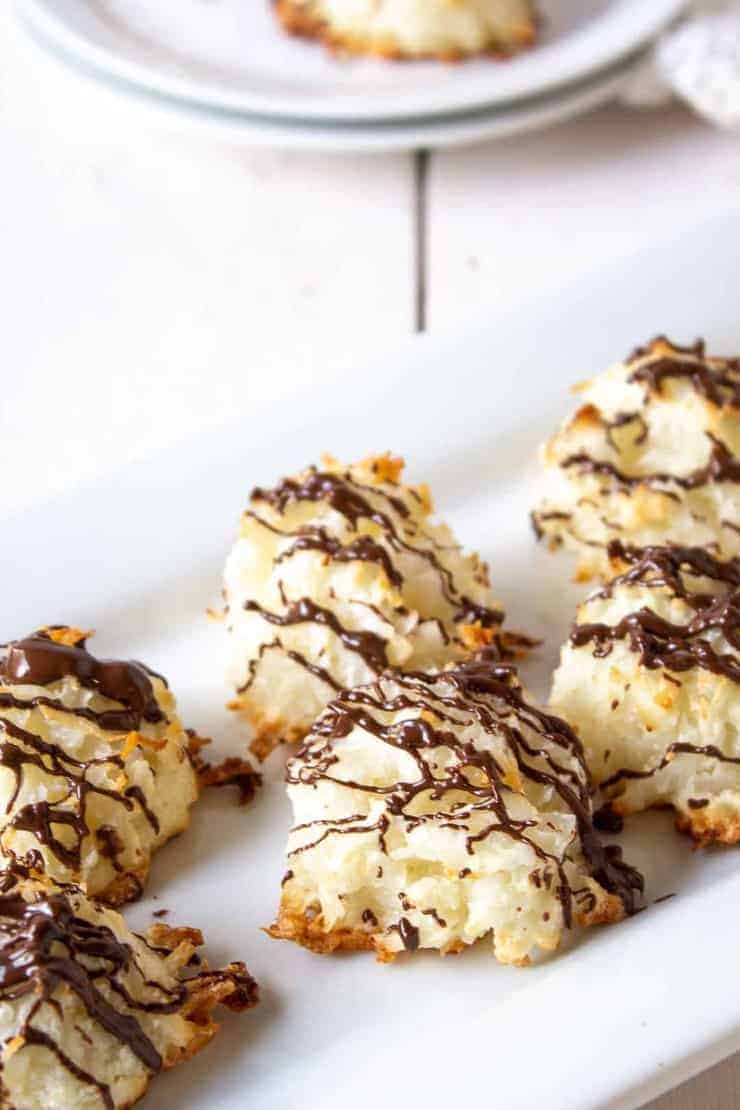 Coconut Macaroons with drizzled chocolate on a white platter.