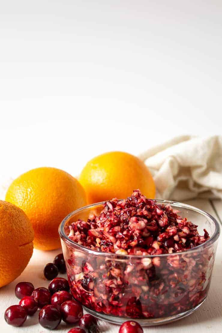 Chopped cranberries with orange peel in a small glass bowl.