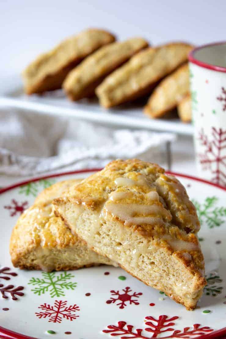 Two scones with topped with a glaze on a snowflake patterned plate. 