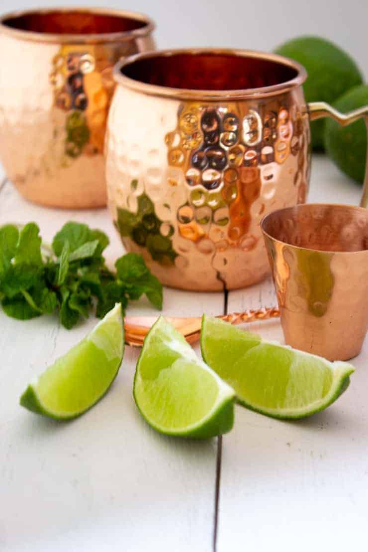 Fresh cut limes and mint for in front of Moscow Mule mugs.