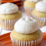 Cupcakes with frosting on orange plates.