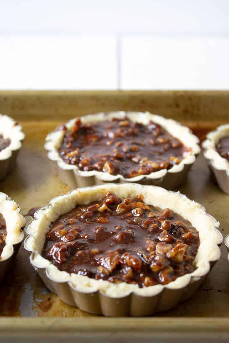 Tart crusts filled with a chocolate walnut filling.