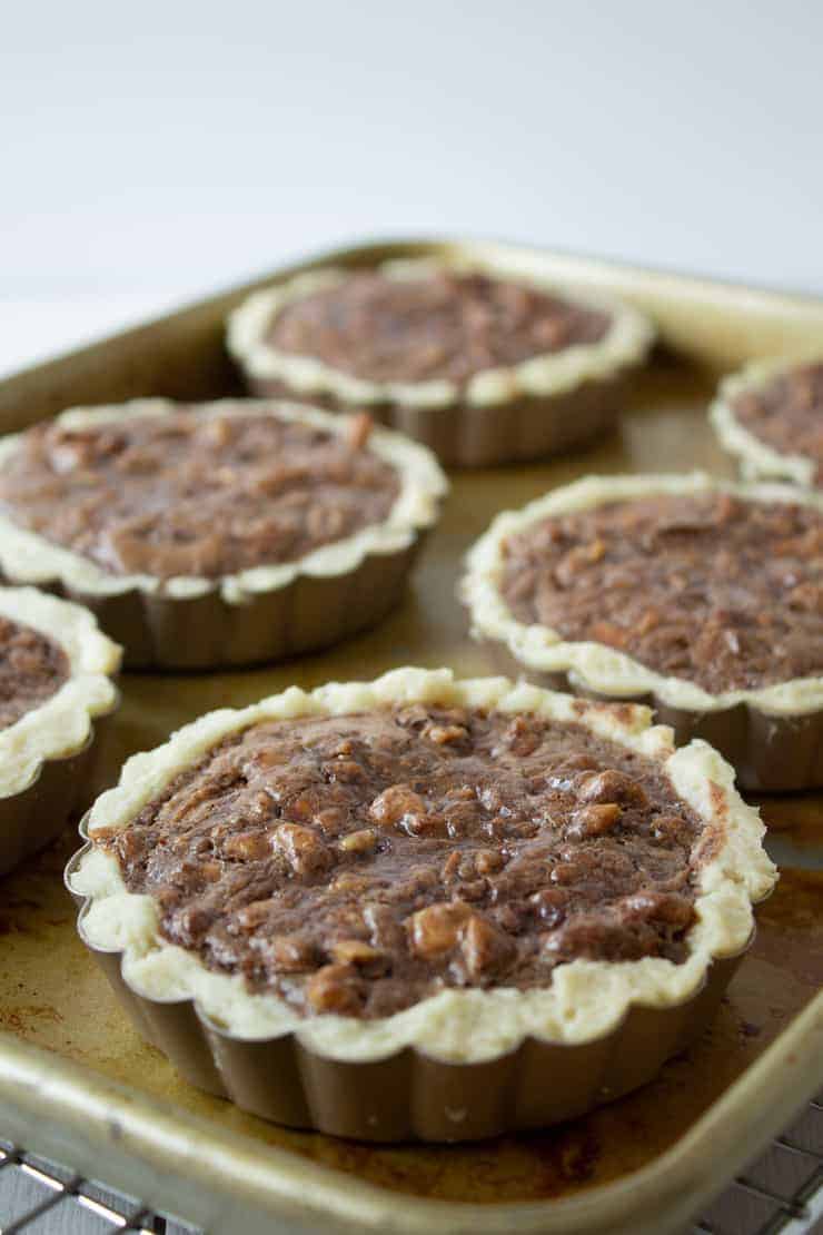 Chocolate Walnut Tarts cooling on a baking sheet.