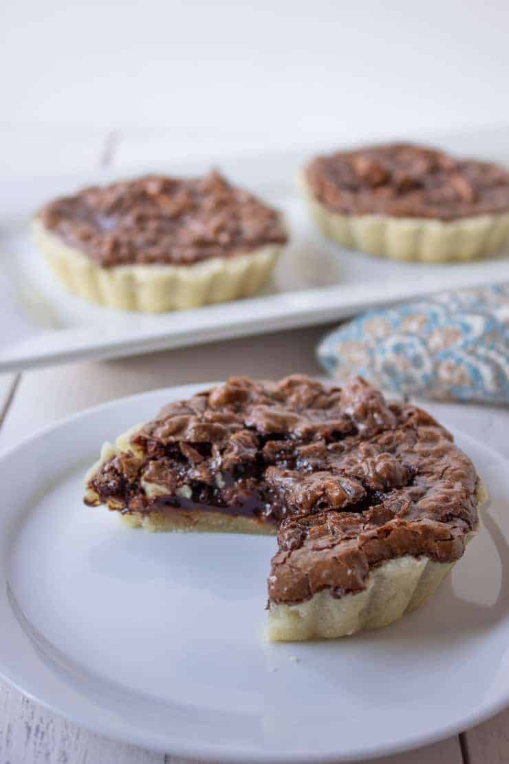  A mini chocolate tart with a slice missing.