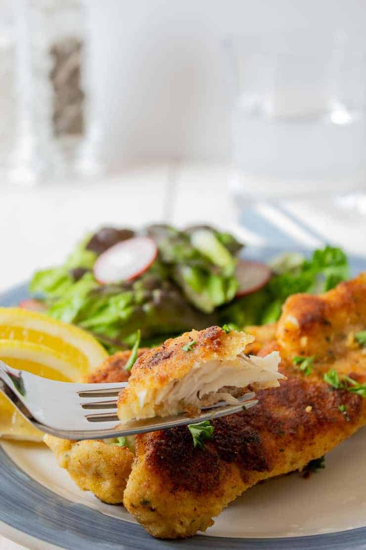 Crispy fried fish on a fork.