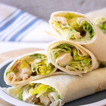 Chicken Caesar Wraps piled on a small blue and white plate.