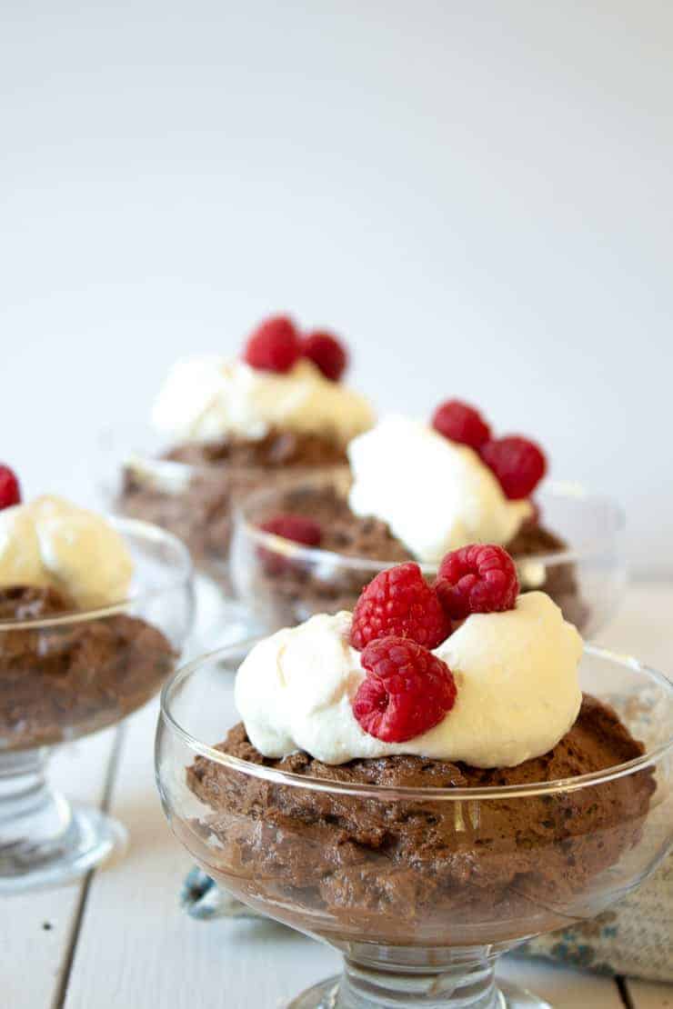 Homemade Chocolate Mousse topped with whipped cream and fresh raspberries.