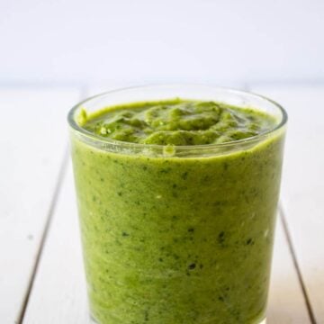 Green Smoothie in a glass on a white board.