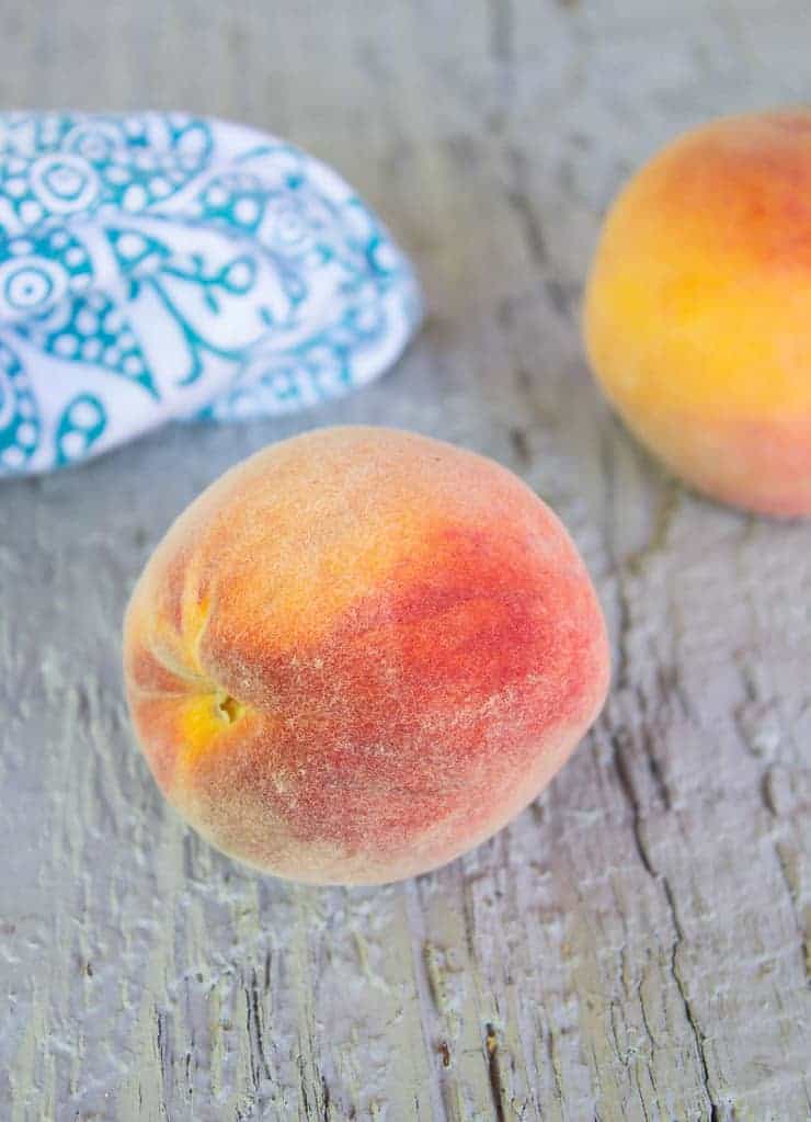 Fresh peaches on a gray board.
