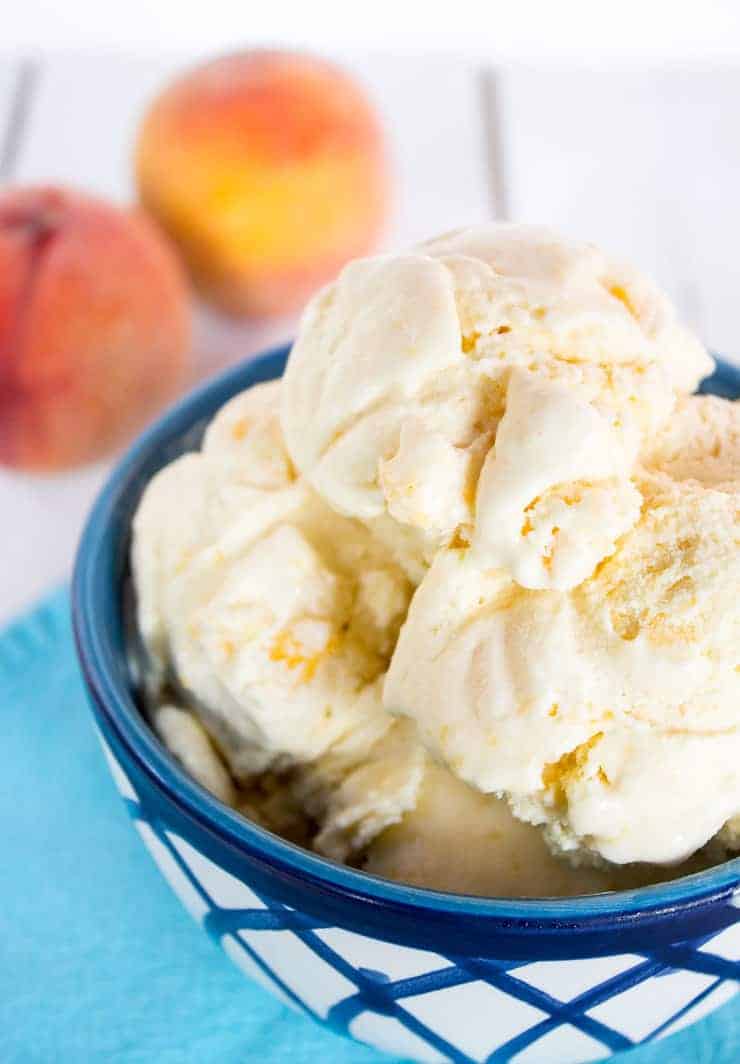 A bowlful of peach ice cream in a blue and white bowl.