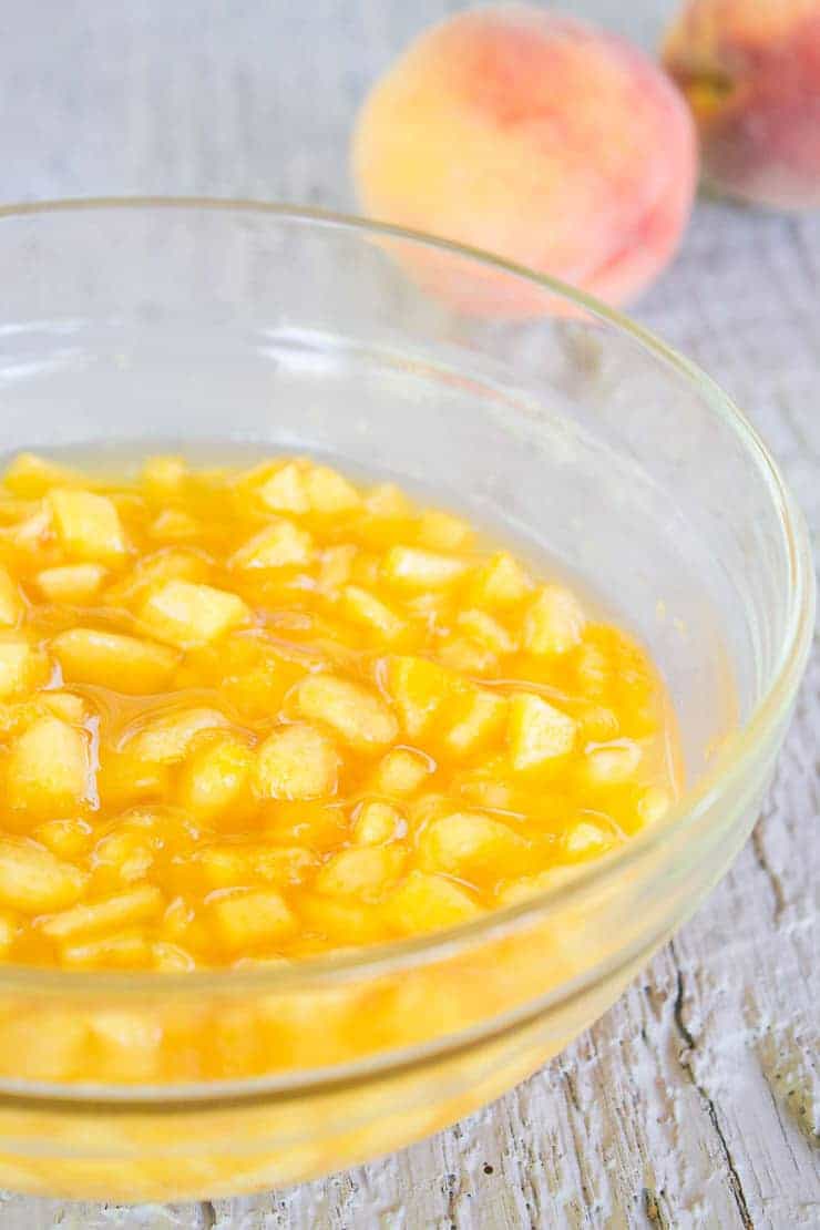 Chopped fresh peaches in a glass bowl.