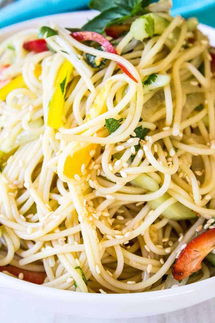 Thai Pasta Salad topped with sesame seeds in a white bowl.