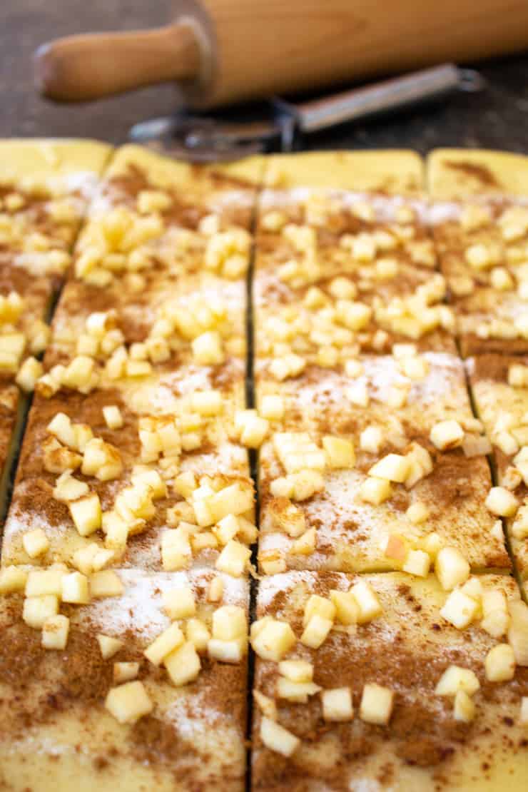 Dough sprinkled with cinnamon, sugar and apples