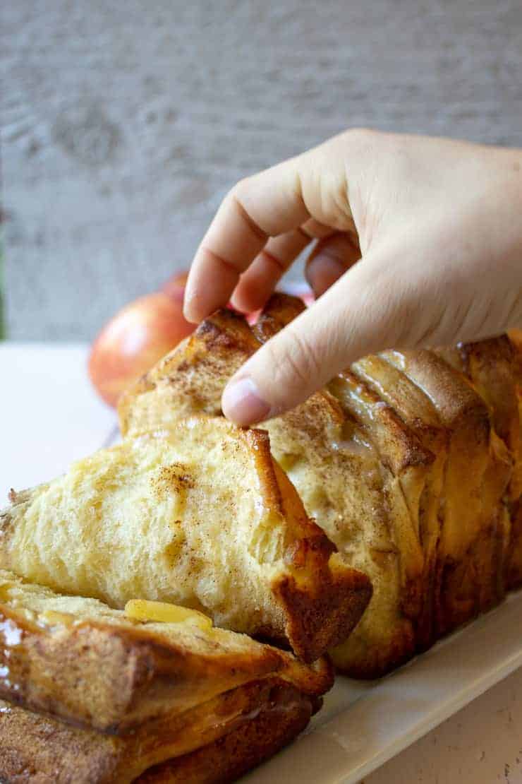 Taking a slice of apple pull apart bread