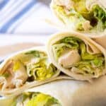 Tortillas wrapped around chicken and caesar salad.