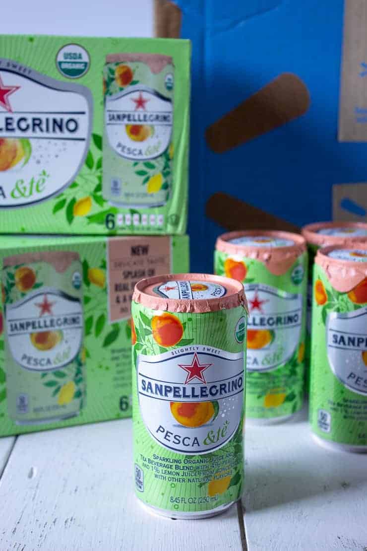 Sanpellegrino cans in front of a Walmart box.