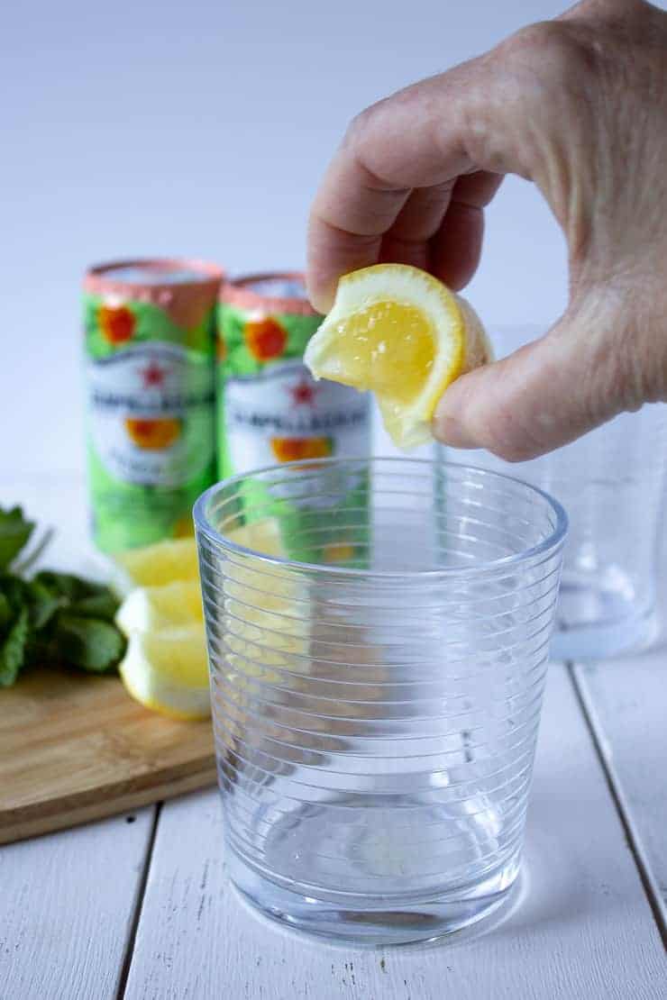 Squeezing a lemon into a glass