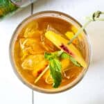 Sparkling Lemon Peach Tea with a fresh mint leave and a slice of peach for a garnish.