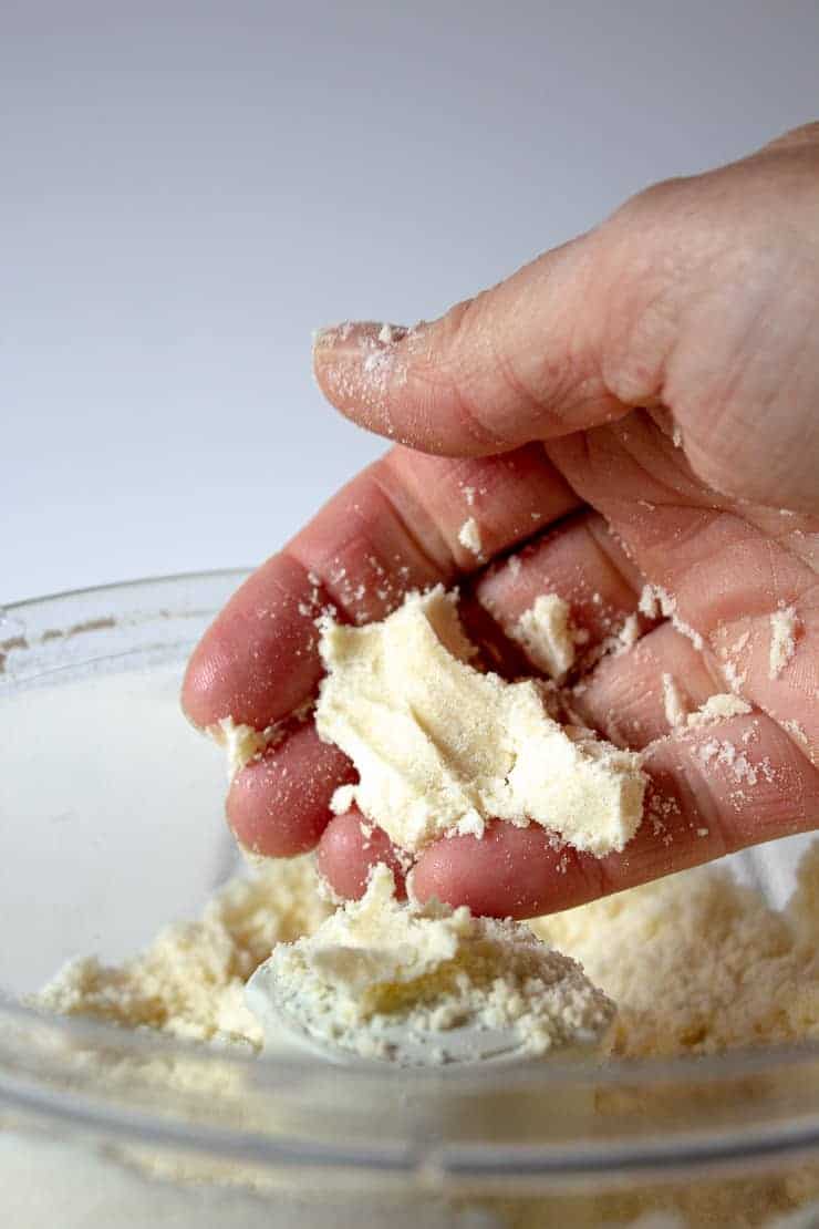 Dough formed together and held in a hand.