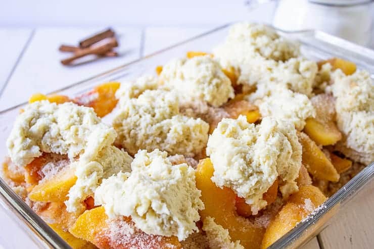 Peach slices topped with mounds of biscuit dough.