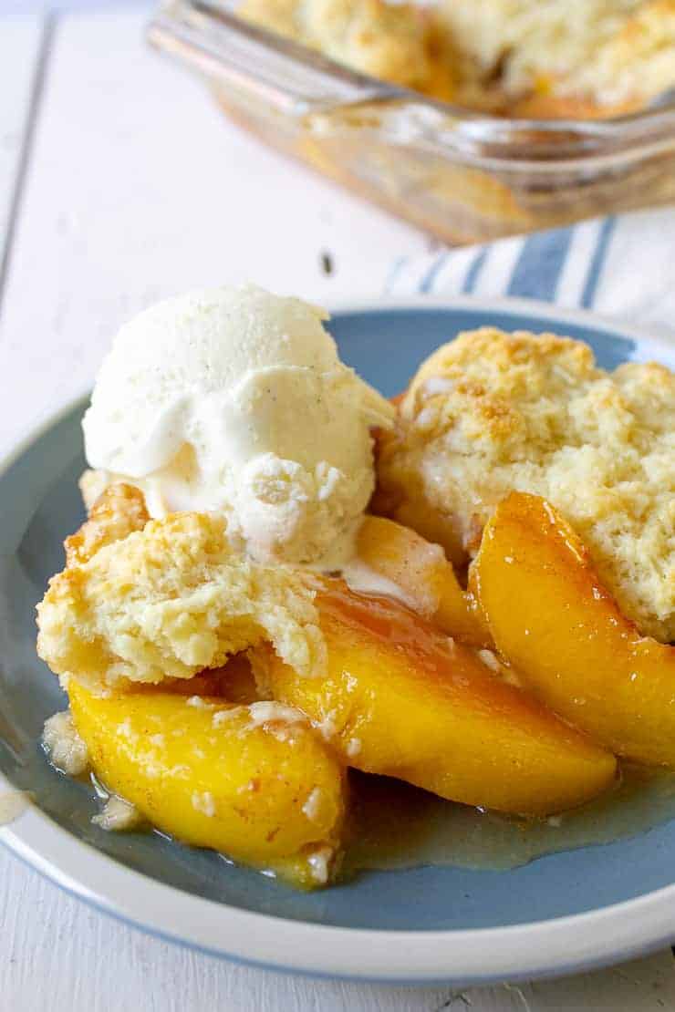 Peach slices topped with biscuits and vanilla ice cream.
