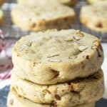 Three pecan cookies stacked on a piece of black slate.