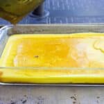 Yellow beeswax in a glass dish.