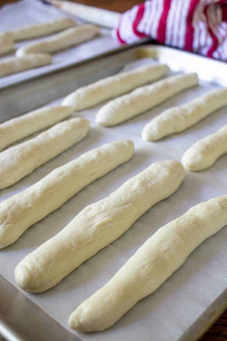 A baking sheet full of unbaked breadsticks. 