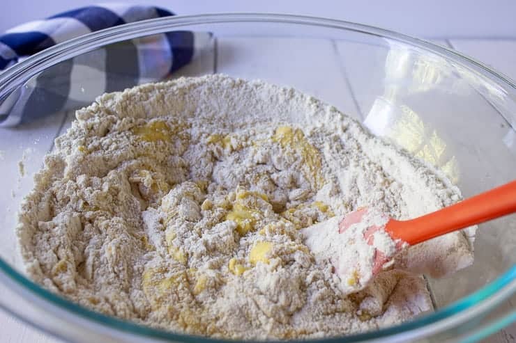 Cake batter being mixed together with an orange spatula.