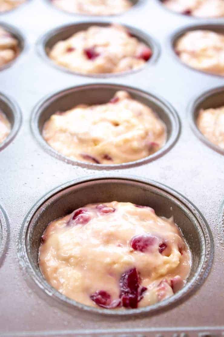 Muffin batter in a muffin tin without paper liners.