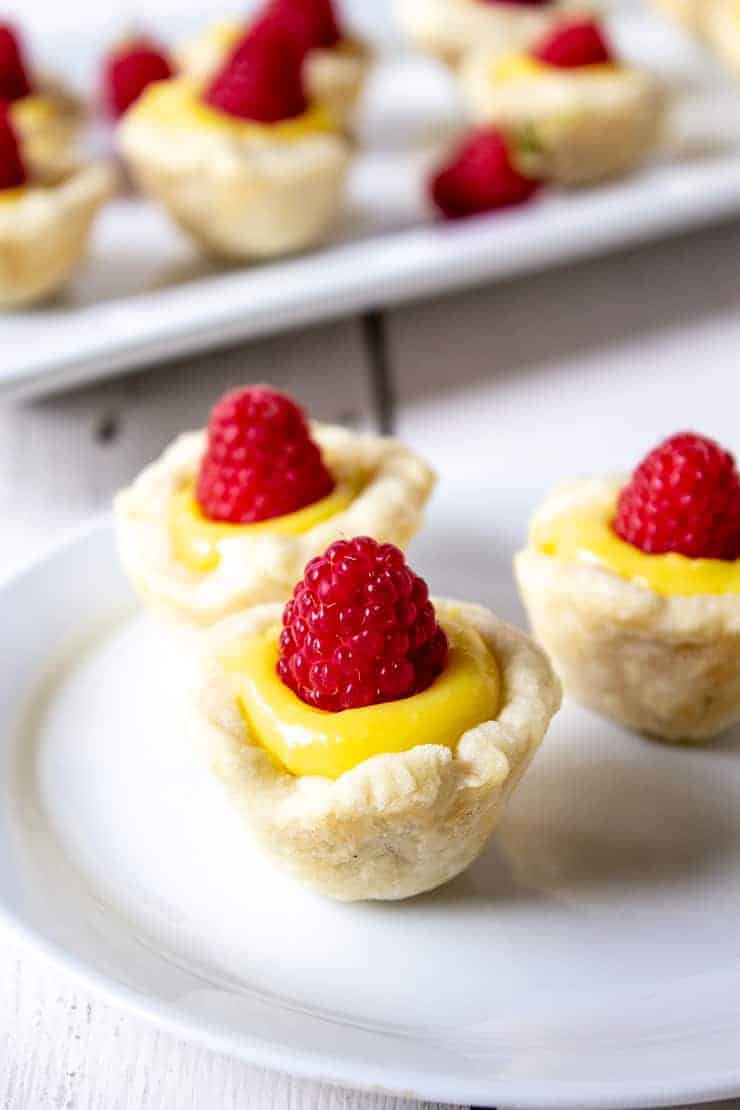 Mini pie crusts filled with lemon curd and topped with fresh raspberries.