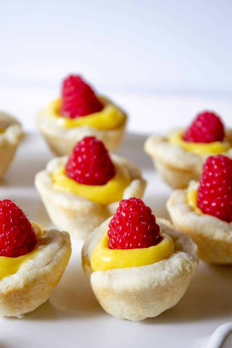 Mini tarts filled with lemon curd and topped with fresh raspberries.