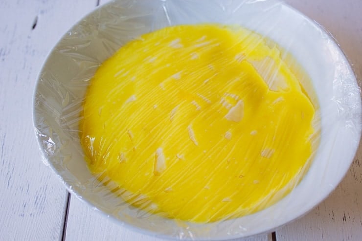 Lemon curd topped with plastic wrap.