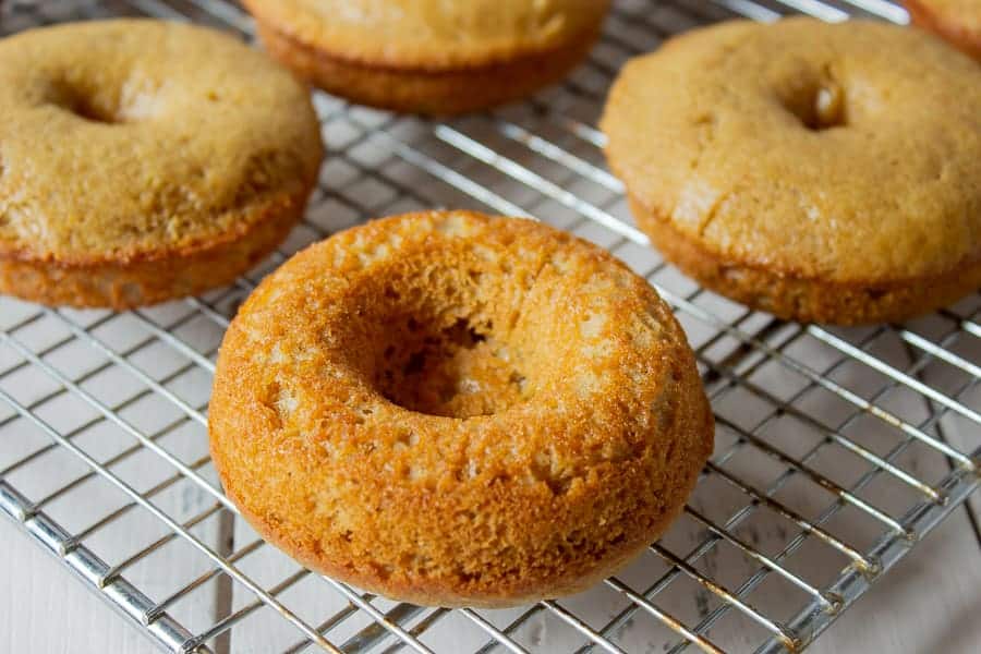 Baked donuts cooling on a rack.