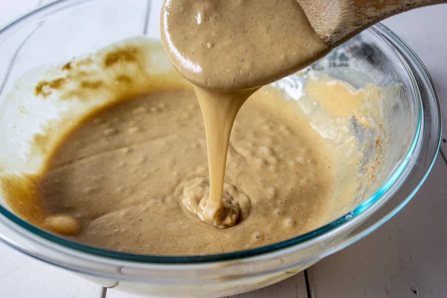 Donut batter dripping off a spoon.