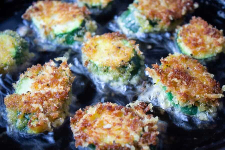 Golden zucchini slices in a pan.