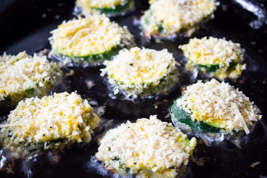 Breaded zucchini in a pan with hot oil.