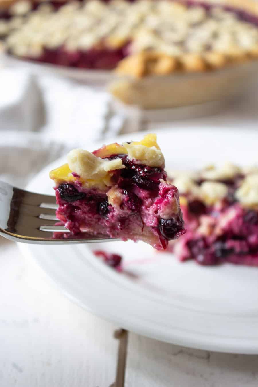 A fork with a bite of huckleberry pie.